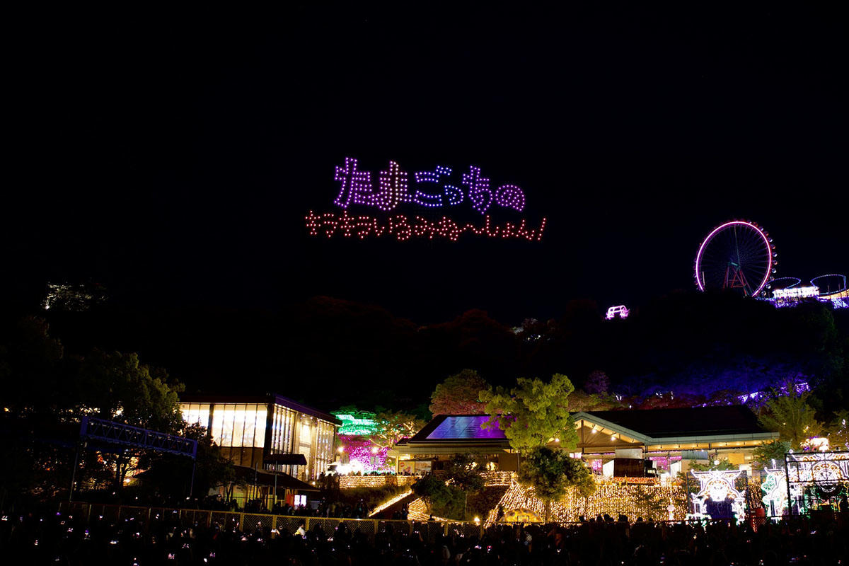さがみ湖MORI MORIの夜空に「たまごっちのキラキラいるみね～しょん！」のロゴが描かれたドローンショーの様子